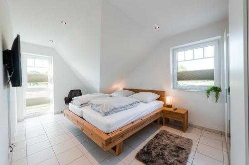 a bedroom with a bed with white sheets and pillows at Ferienpark Harkebrügge Haus Juist in Barßel