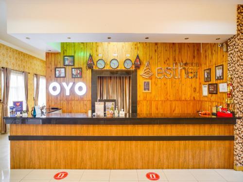 un bar en un restaurante con paredes de madera en SUPER OYO Capital O 540 Esther Hotel, en Balige