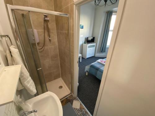 a bathroom with a shower and a toilet and a sink at The Bay En-suite Room in Plymouth