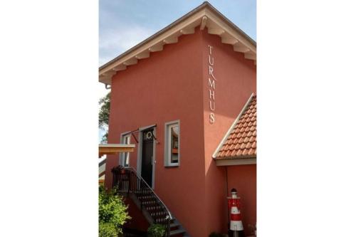 a red building with stairs on the side of it at Turmhus Bansin in Gothen