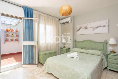 een slaapkamer met een groen bed en een raam bij Koti Rentals - Ático Marconi in Fuengirola