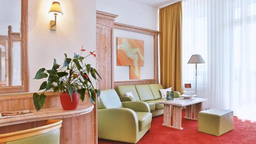 a living room with a couch and a table at Wellness-& Nationapark Hotel Schliffkopf, BWSC in Baiersbronn
