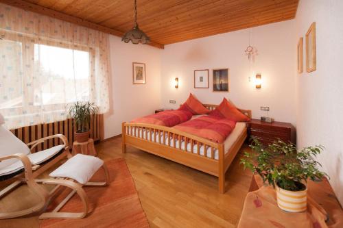 a bedroom with a large bed with red pillows at Ferienhaus "Lisa´s Häusl" in Neuschönau