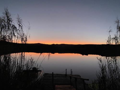 a sunset over a body of water with a dock at Kadie's Landing House - Living The Breede in Malgas
