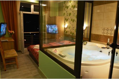 a bathroom with a tub and a bedroom with a bed at Live Inn Bulgaria town Svishtov in Svishtov