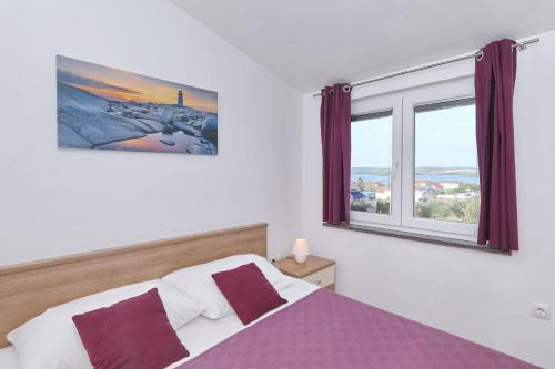 una camera con un letto viola e bianco e una finestra di Apartments BoBo a Kraj