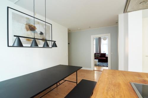 ein Esszimmer mit einem Tisch und einem Gemälde an der Wand in der Unterkunft Large Modern Flats By Meat Packing District in central Copenhagen in Kopenhagen