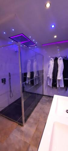 Habitación púrpura con lavabo y ropa en una habitación en Dydy's love en Lecelles