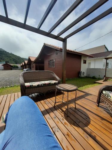 a wooden deck with a pergola and a bench at Pousada Morada dos Sonhos in Urubici