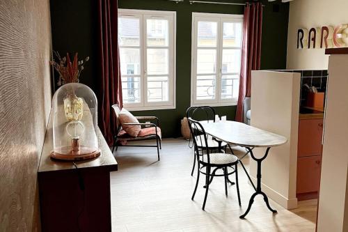 - une cuisine avec une table, une table et des chaises dans l'établissement Duplex 50m2 rénové, hyper-centre, St sauveur, à Caen