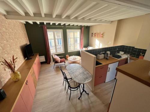- une cuisine avec une table et des chaises dans la chambre dans l'établissement Duplex 50m2 rénové, hyper-centre, St sauveur, à Caen
