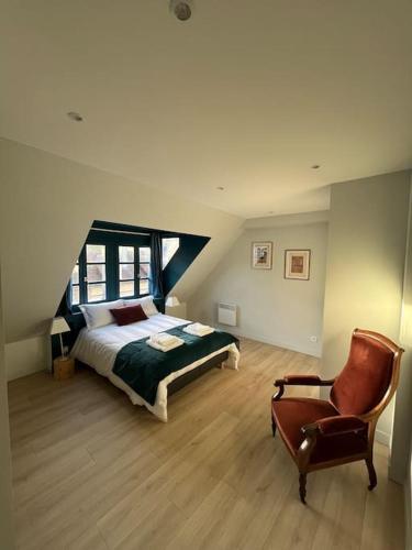 une chambre avec un lit et une chaise dans l'établissement Duplex 50m2 rénové, hyper-centre, St sauveur, à Caen
