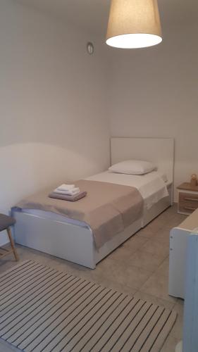 a white bedroom with a bed with a white wall at Kuća za odmor-Val in Vir