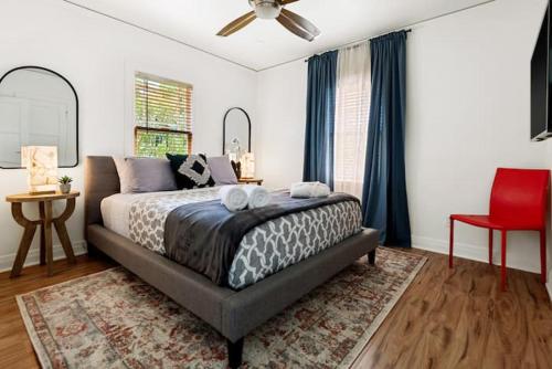 1 dormitorio con 1 cama grande y 1 silla roja en Culver city 2 bedroom walking distance to downtown unit B, en Los Ángeles