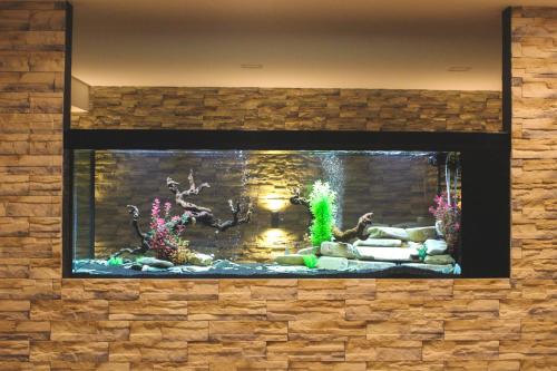 a large aquarium with two fish in a brick wall at Hotel Alf in Borovany