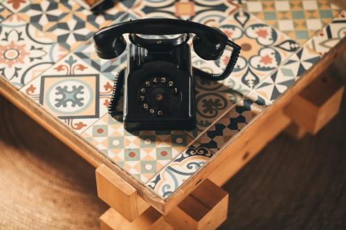 un teléfono negro sentado en una mesa de madera en Casa da Bia, en Conceição