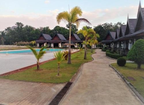 ein Resort mit einem Pool und Palmen in der Unterkunft PARADIS VERT in Ban Khao Thong