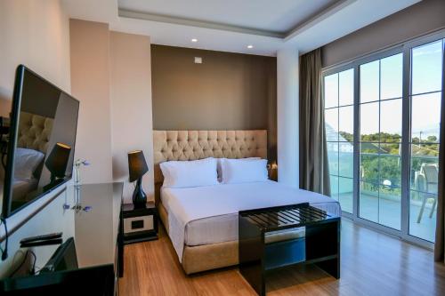 a bedroom with a bed and a large window at Hotel Luxury in Ksamil