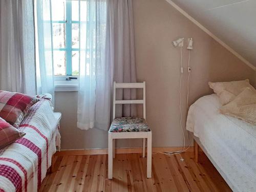 フィンスネスにあるHoliday home Finnsnesのベッドと窓のある部屋の椅子