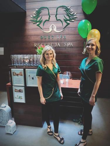 two women standing in front of a bar with balloons at Hotel Szarlota - Kompleksowo na Kaszubach in Kościerzyna