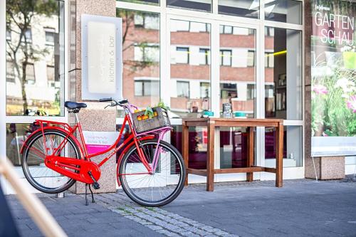 a red bike parked in front of a building at Hotel Indigo - Dusseldorf - Victoriaplatz by IHG in Düsseldorf