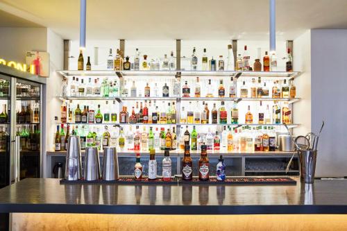 a bar with a lot of bottles of alcohol at Hotel Indigo - Dusseldorf - Victoriaplatz by IHG in Düsseldorf
