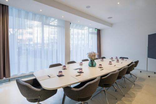 a conference room with a long table and chairs at Hotel Indigo - Dusseldorf - Victoriaplatz, an IHG Hotel in Düsseldorf