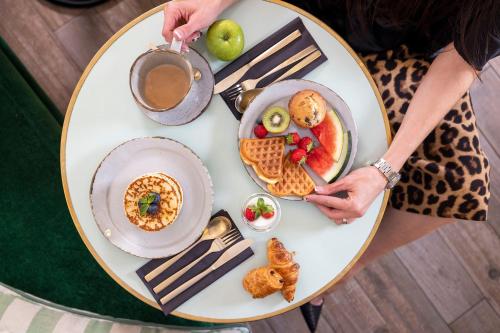 un tavolo con un piatto di prodotti per la colazione di Hotel Fior d'Aliza a Parigi