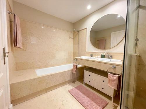 a bathroom with a tub and a sink and a mirror at Luxurious 2 bedroom apartment with Spa facilities in Benahavís