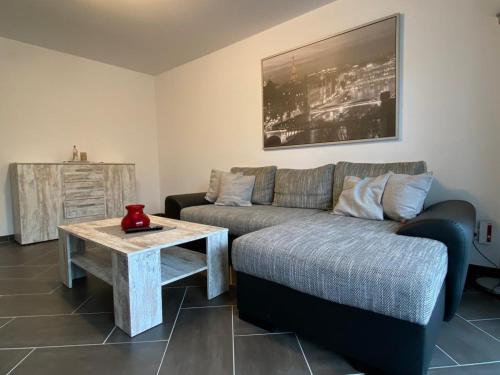 een woonkamer met een bank en een tafel bij Gästewohnung 3 in Oschersleben