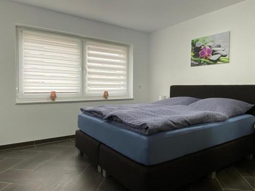 een slaapkamer met een bed en 2 ramen bij Gästewohnung 3 in Oschersleben