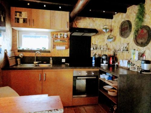 uma cozinha com armários de madeira e um lavatório em Chalet Lisba em Comblain-la-Tour