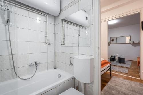 ein weißes Badezimmer mit Badewanne und Dusche in der Unterkunft Mirage Monte Apartment in Budapest