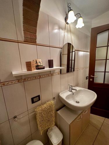 a bathroom with a sink and a toilet and a mirror at LA TAVERNA tra gli ulivi in Perinaldo