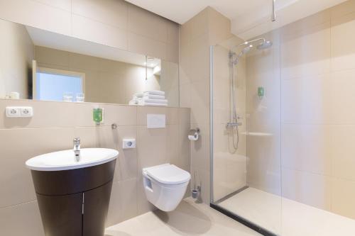 a bathroom with a toilet sink and a shower at Amrâth Hotel Bigarré in Maastricht