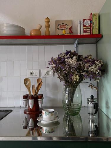 blat kuchenny z wazonem kwiatów i kubków w obiekcie My Wooden Apartments w Tiranie