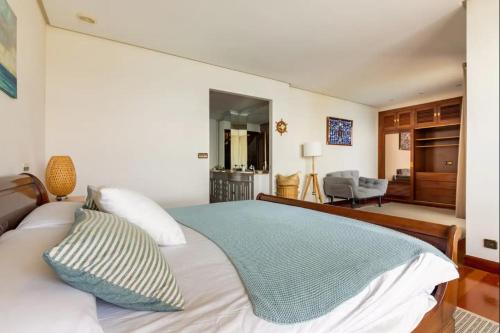 Un dormitorio con una cama con una manta azul. en VILLA ENSUEÑO UNCETA GETARIA, en Getaria
