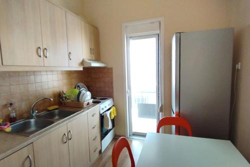 a kitchen with a sink and a refrigerator at Cozy μικρό διαμέρισμα κοντά στο λιμάνι in Egina