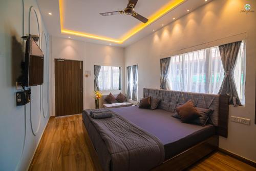 a large bed in a room with a ceiling fan at Eden Garden in Alibaug