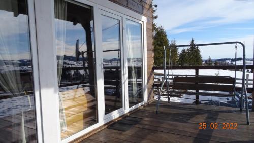a balcony with glass doors and a view of the water at Casuta Schiorului in Mărişel