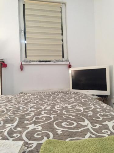 a bedroom with a bed and a flat screen tv at Hostel Lega House in Osijek