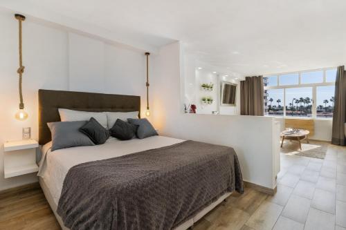 a bedroom with a large bed and a large window at Los Molinos 202 in Maspalomas