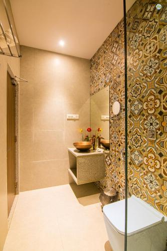 a bathroom with a shower and a sink and a toilet at Eden Garden in Alibaug