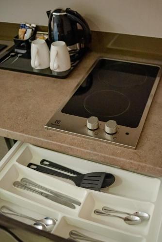 a kitchen counter with a stove top with silver utensils at Radisson Serviced Apartments Antananarivo City Centre in Antananarivo