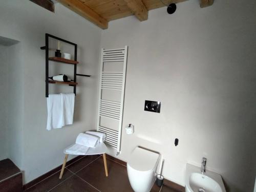 a white bathroom with a toilet and a sink at Dimora DarSenso in Albaretto Della Torre 