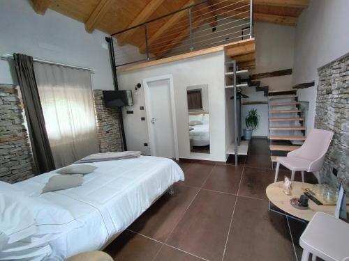 a bedroom with a large bed and a staircase at Dimora DarSenso in Albaretto Della Torre 