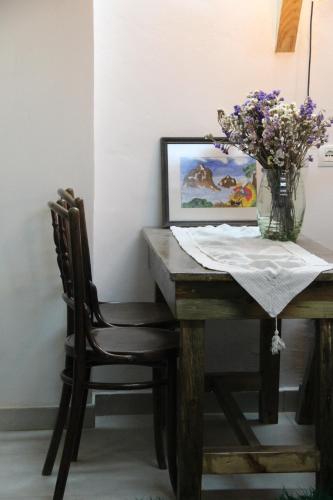 stół jadalny z wazonem kwiatów w obiekcie My Wooden Apartments w Tiranie