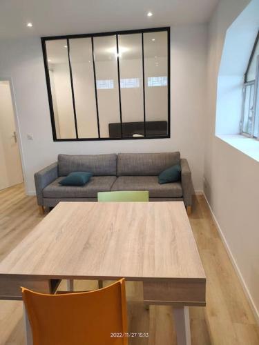 a living room with a table and a couch at Logement complet à Villeurbanne in Villeurbanne