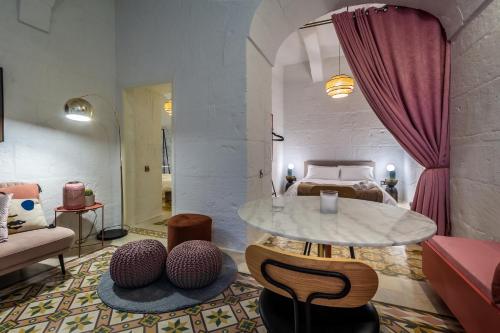 - un salon avec une table et un lit dans l'établissement Impressive & stylish Palazzino in Valletta DDEM1-3, à La Valette