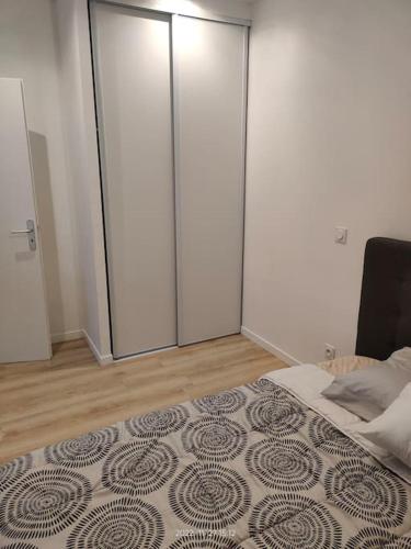 - une chambre avec des portes coulissantes en verre et un lit dans l'établissement Logement complet à Villeurbanne, à Villeurbanne